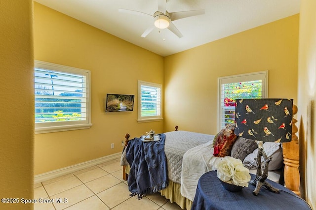 tiled bedroom featuring a ceiling fan and baseboards