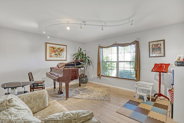 interior space featuring baseboards, wood finished floors, and track lighting