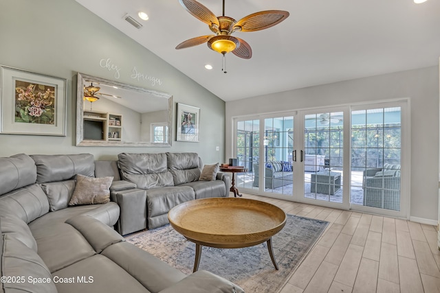 living area featuring a wealth of natural light, light wood-type flooring, visible vents, and ceiling fan