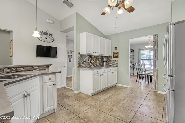 kitchen with ceiling fan with notable chandelier, white cabinetry, freestanding refrigerator, light tile patterned floors, and lofted ceiling