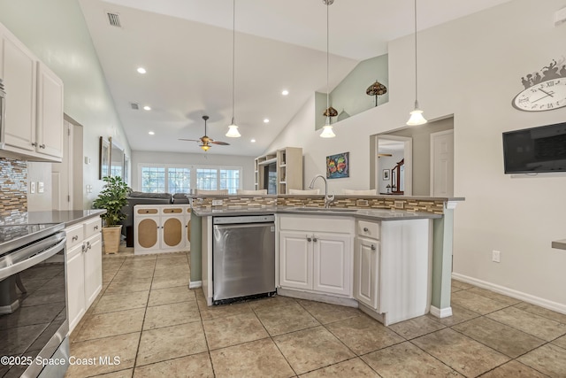 kitchen featuring open floor plan, white cabinets, stainless steel appliances, a ceiling fan, and a sink