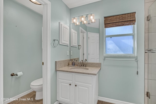 full bathroom with vanity, toilet, baseboards, and an enclosed shower