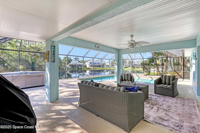 view of patio / terrace with a water view, a lanai, a ceiling fan, and a hot tub