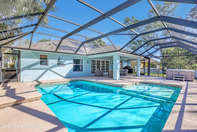 outdoor pool featuring a patio area, a lanai, and a hot tub