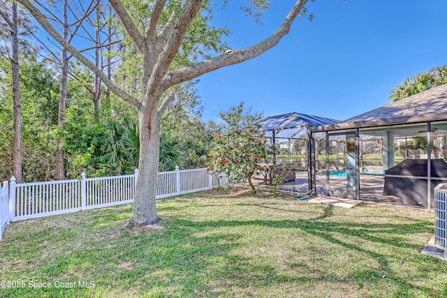 view of yard with glass enclosure, an outdoor pool, and a fenced backyard