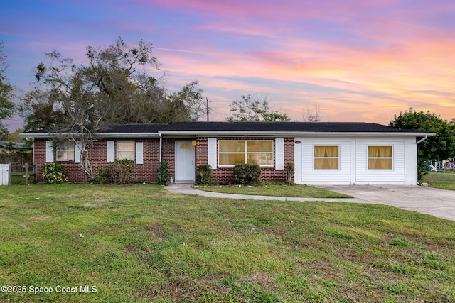 ranch-style home featuring a lawn and brick siding