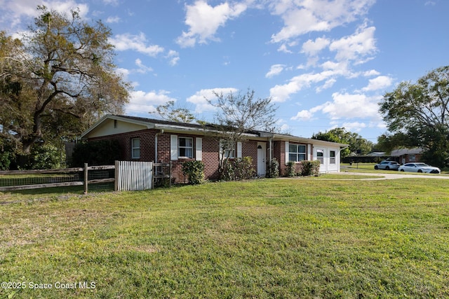 ranch-style home featuring a front yard, fence, and brick siding