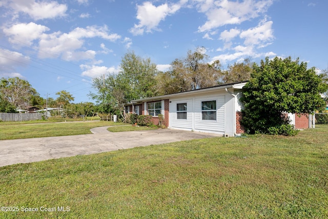 view of front of home with brick siding, driveway, a front yard, and fence