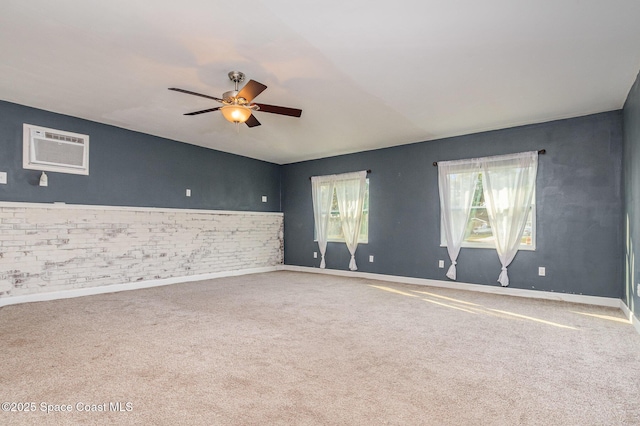 unfurnished room featuring a ceiling fan, baseboards, carpet floors, and a wall mounted AC