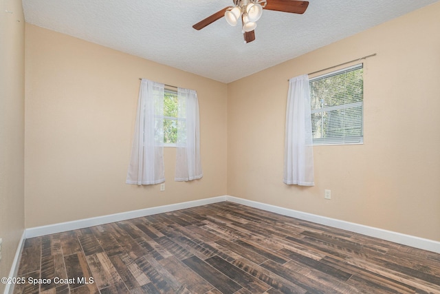 empty room with baseboards, a ceiling fan, and dark wood-style flooring