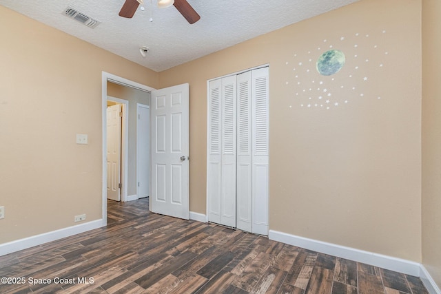 unfurnished bedroom with visible vents, baseboards, a textured ceiling, and wood finished floors