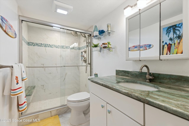 full bathroom featuring vanity, toilet, marble finish floor, and a stall shower