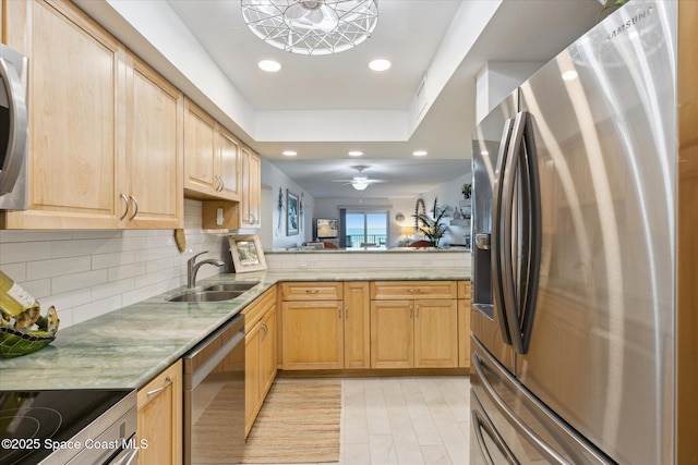 kitchen featuring light brown cabinetry, decorative backsplash, recessed lighting, stainless steel appliances, and a sink