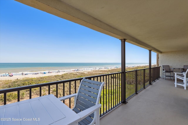 balcony featuring a beach view and a water view