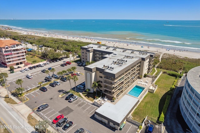 drone / aerial view featuring a beach view and a water view