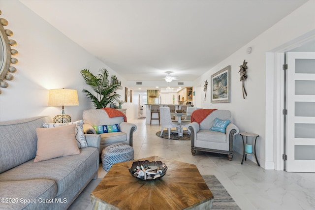 living area featuring marble finish floor and ceiling fan