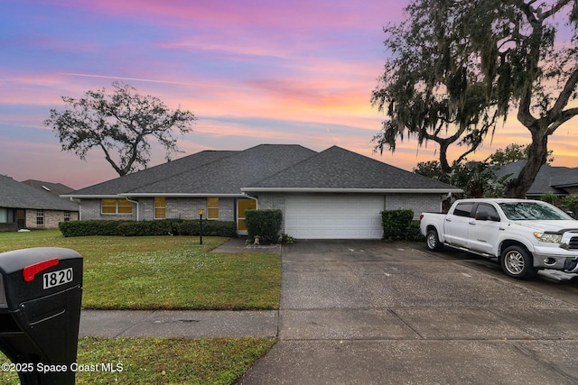 view of front of home featuring brick siding, a front lawn, concrete driveway, roof with shingles, and a garage