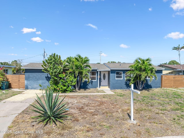 ranch-style house with stucco siding and fence