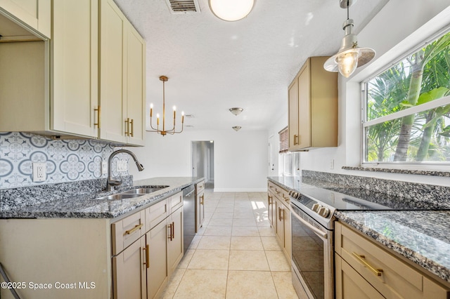 kitchen featuring visible vents, a sink, dark stone countertops, stainless steel appliances, and light tile patterned floors