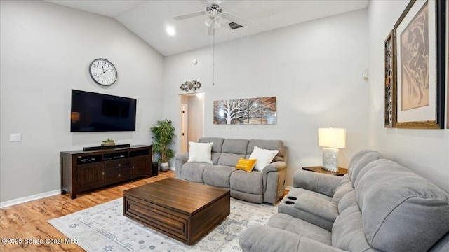 living area with a ceiling fan, visible vents, baseboards, light wood finished floors, and high vaulted ceiling