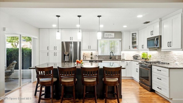 kitchen with visible vents, a healthy amount of sunlight, stainless steel appliances, and a sink