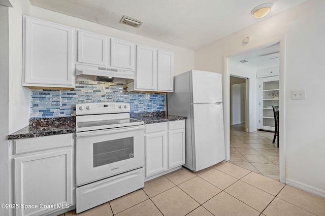 kitchen with white appliances, visible vents, light tile patterned flooring, white cabinets, and under cabinet range hood