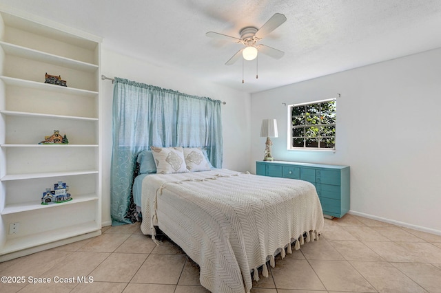 bedroom featuring light tile patterned floors, baseboards, a textured ceiling, and a ceiling fan