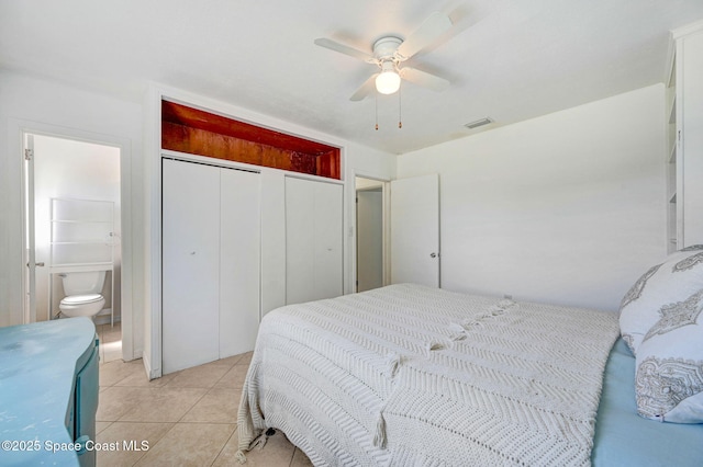 bedroom with visible vents, ceiling fan, light tile patterned floors, ensuite bathroom, and a closet