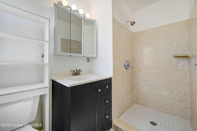 bathroom featuring tiled shower, toilet, and vanity