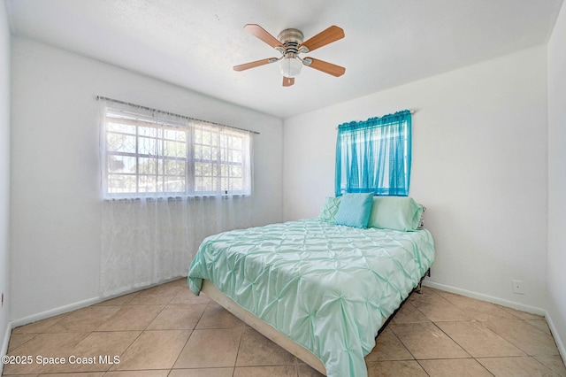 tiled bedroom with a ceiling fan and baseboards