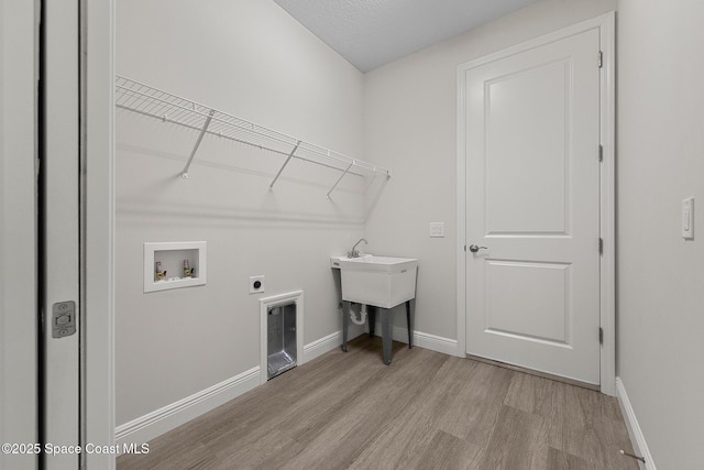 laundry area with baseboards, hookup for an electric dryer, laundry area, washer hookup, and light wood-type flooring