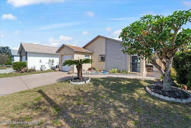 view of front of property featuring stucco siding, an attached garage, driveway, and a front yard