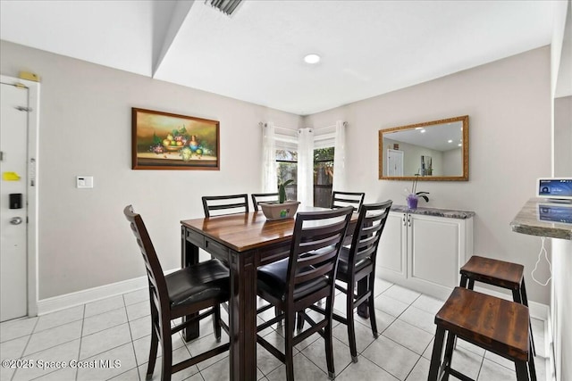 dining area featuring light tile patterned floors, visible vents, and baseboards