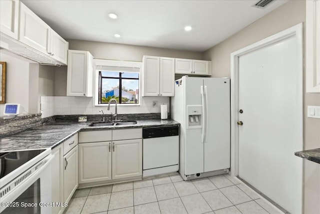 kitchen featuring a sink, white appliances, white cabinets, light tile patterned floors, and decorative backsplash