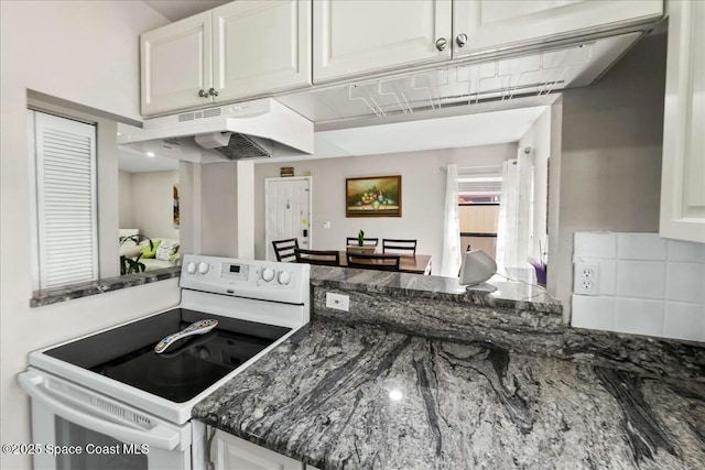 kitchen featuring electric stove, under cabinet range hood, tasteful backsplash, white cabinetry, and dark stone counters