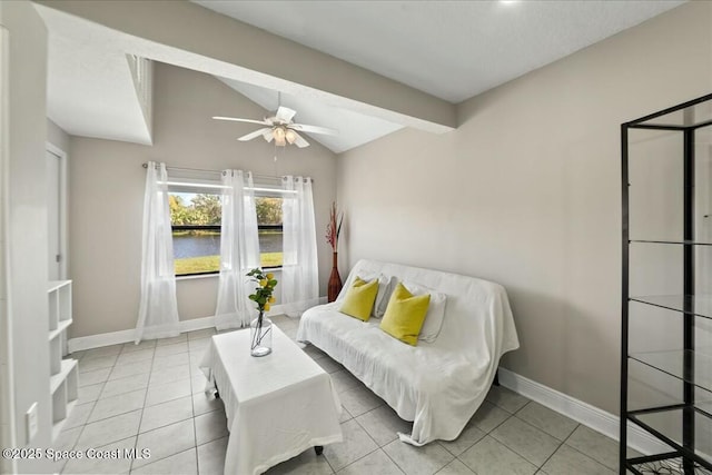 tiled living room featuring vaulted ceiling, baseboards, a water view, and ceiling fan