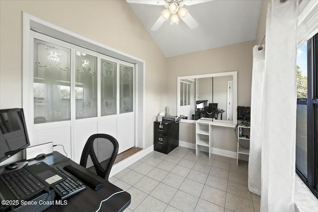 office space with baseboards, lofted ceiling, light tile patterned flooring, and a ceiling fan