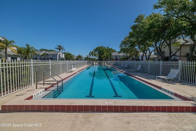 community pool with a patio and fence