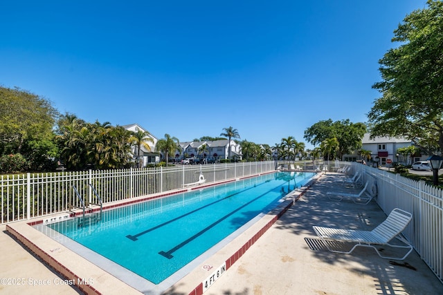 community pool featuring a residential view and fence