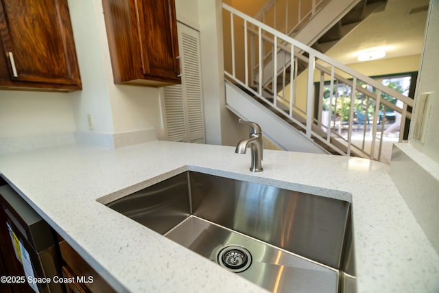 room details featuring light stone counters and a sink