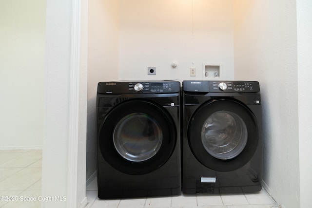 laundry area featuring tile patterned floors, washing machine and dryer, and baseboards