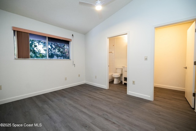 unfurnished bedroom with ceiling fan, baseboards, dark wood finished floors, lofted ceiling, and ensuite bath