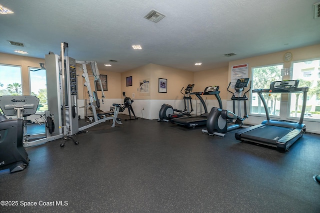 gym with visible vents and a textured ceiling