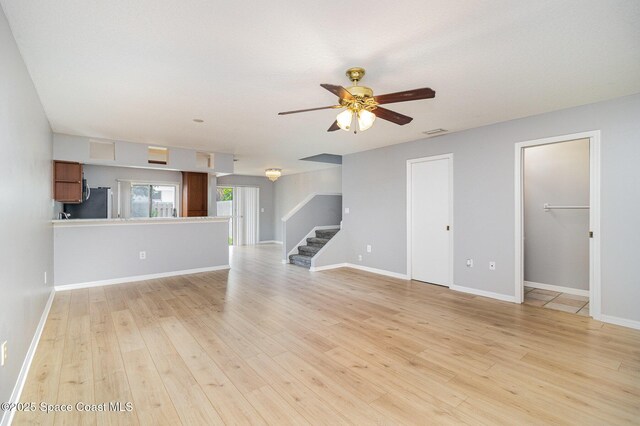 211 Cherie Down Ln, Cape Canaveral, FL 32920 - unfurnished living room with stairway, ceiling fan, and light wood-type flooring