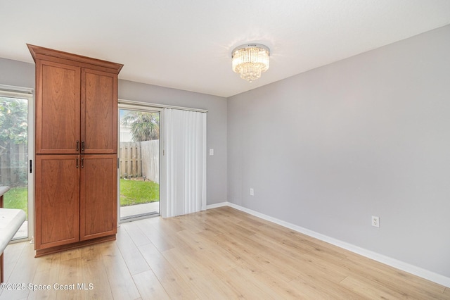211 Cherie Down Ln, Cape Canaveral, FL 32920 - spare room with healthy amount of natural light, a chandelier, and light wood-style flooring