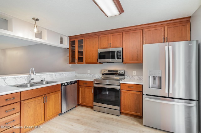 211 Cherie Down Ln, Cape Canaveral, FL 32920 - kitchen with appliances with stainless steel finishes, brown cabinetry, light wood-style flooring, and light countertops