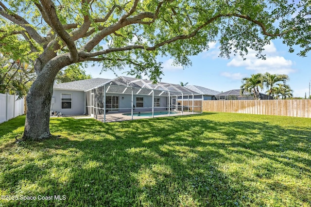 view of yard featuring a lanai, a fenced in pool, and a fenced backyard