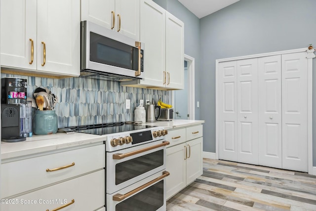 kitchen with white cabinetry, white appliances, and backsplash