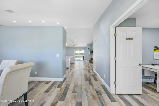 hallway with recessed lighting, light wood-type flooring, and baseboards