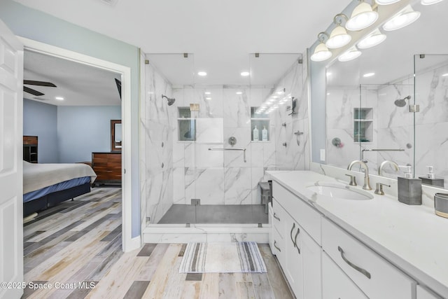 bathroom featuring a marble finish shower, vanity, ensuite bathroom, and wood finished floors